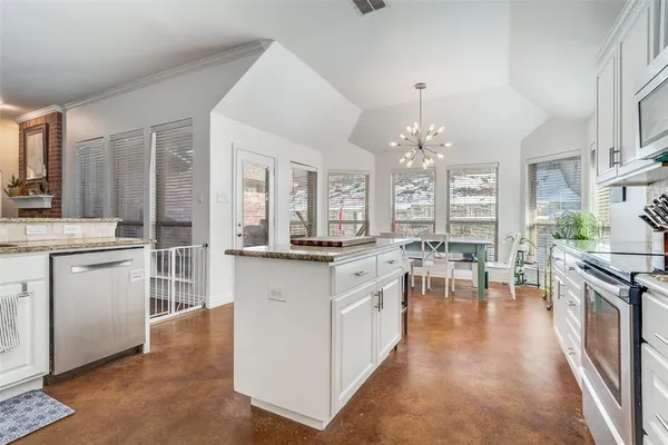a open kitchen with stainless steel appliances granite countertop a stove top oven a sink dishwasher and white cabinets with wooden floor