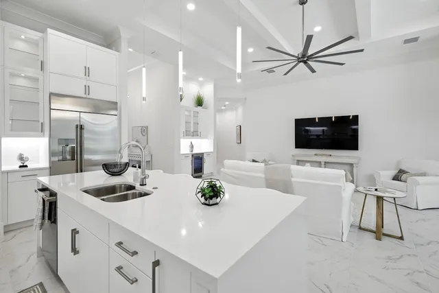 a kitchen with stainless steel appliances a white table chairs and a refrigerator