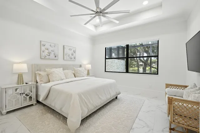 a bedroom with a large bed and a chandelier