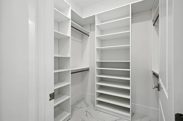 a view of walk in closet with empty racks