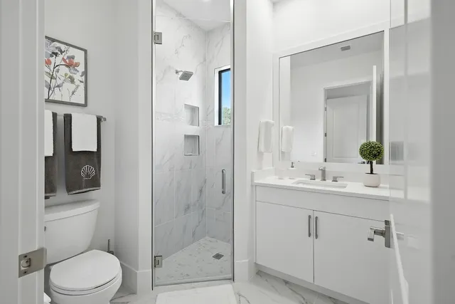 a bathroom with a toilet a sink and shower