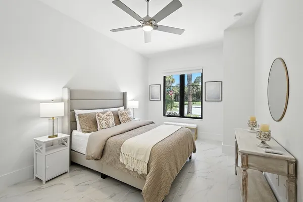 a bedroom with a bed a chandelier and a window
