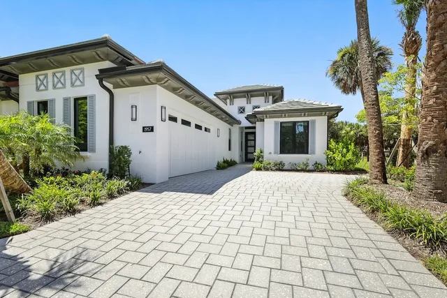 a front view of a house with a yard and potted plants