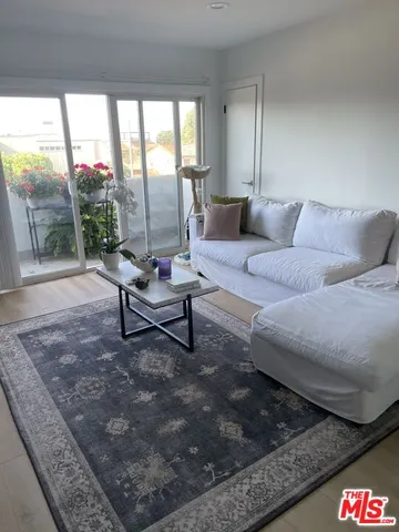 a living room with furniture and a floor to ceiling window