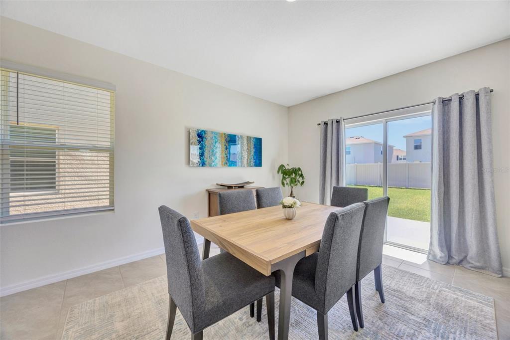 5758 Hollingworth Trail Wesley Chapel, FL 33545 - Photo 11 of 33 a view of a dining room with furniture and a potted plant