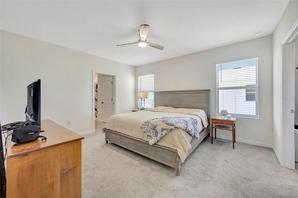 5758 Hollingworth Trail Wesley Chapel, FL 33545 - Photo 16 of 33 a bedroom with a bed and a flat screen tv