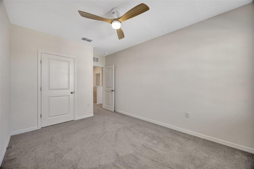 5758 Hollingworth Trail Wesley Chapel, FL 33545 - Photo 22 of 33 an empty room with a ceiling fan and carpet