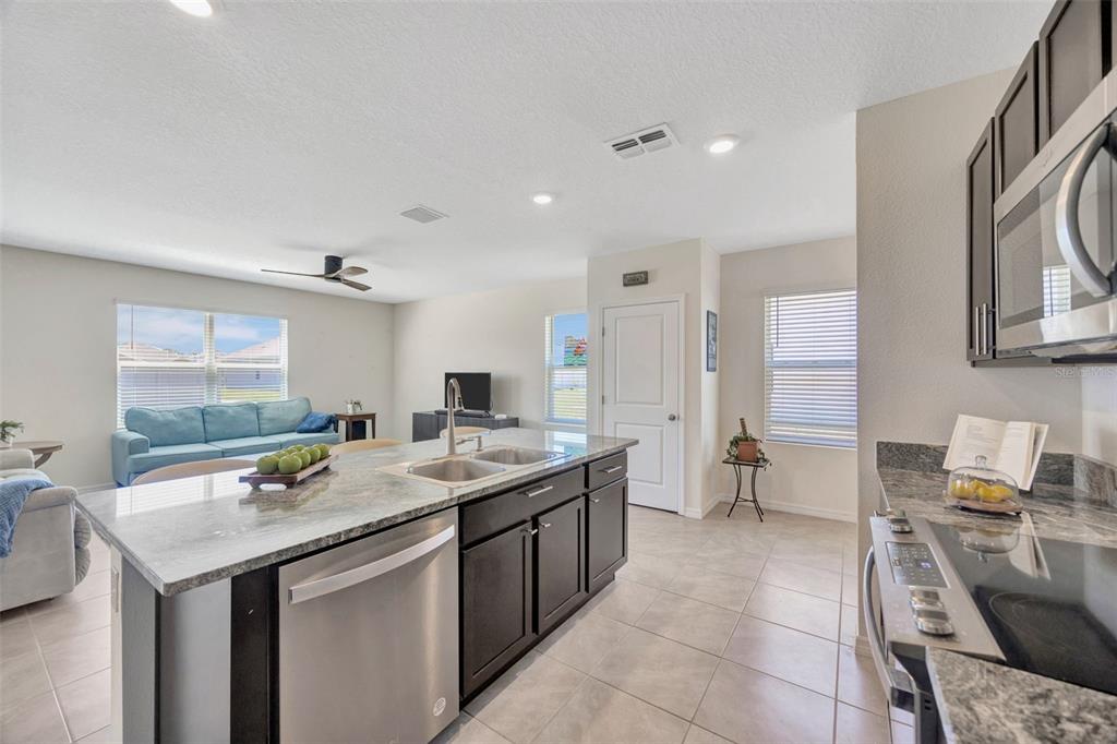 5758 Hollingworth Trail Wesley Chapel, FL 33545 - Photo 5 of 33 a kitchen with a stove a sink and a refrigerator