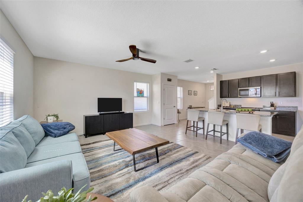 5758 Hollingworth Trail Wesley Chapel, FL 33545 - Photo 7 of 33 a living room with furniture and a view of kitchen
