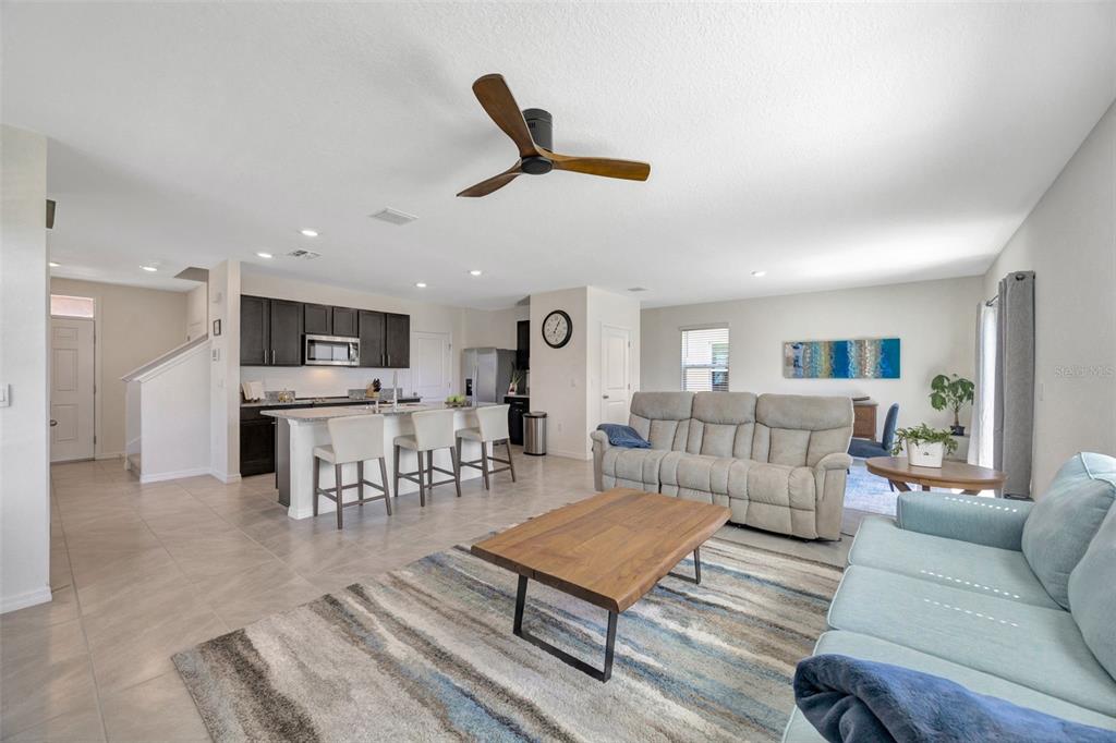 5758 Hollingworth Trail Wesley Chapel, FL 33545 - Photo 8 of 33 a living room with furniture kitchen view and a potted plant