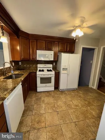a kitchen with a stove a refrigerator and a sink