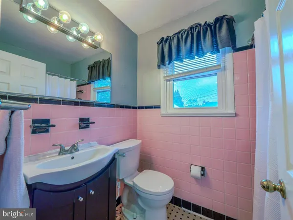 a bathroom with a sink toilet and mirror