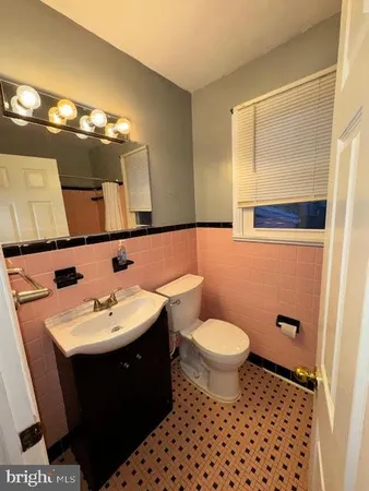 a bathroom with a sink toilet and mirror