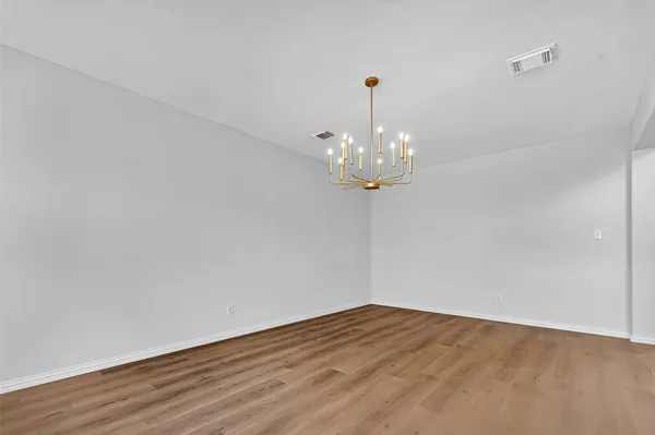 a view of a room with wooden floor and chandelier