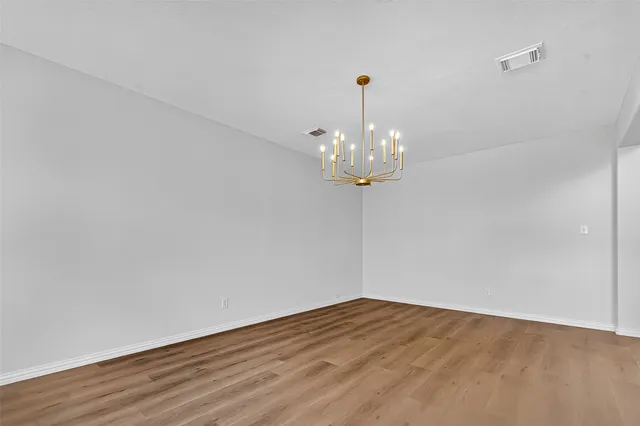 a view of a room with wooden floor and chandelier