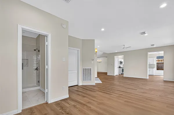 a view of a big room with wooden floor and windows