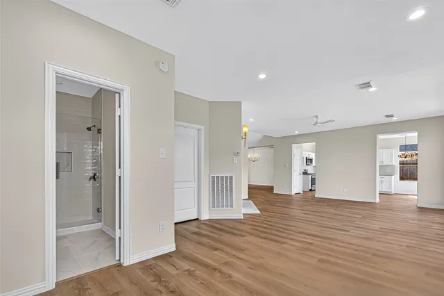 a view of a big room with wooden floor and windows