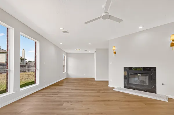 a view of empty room with wooden floor and fireplace
