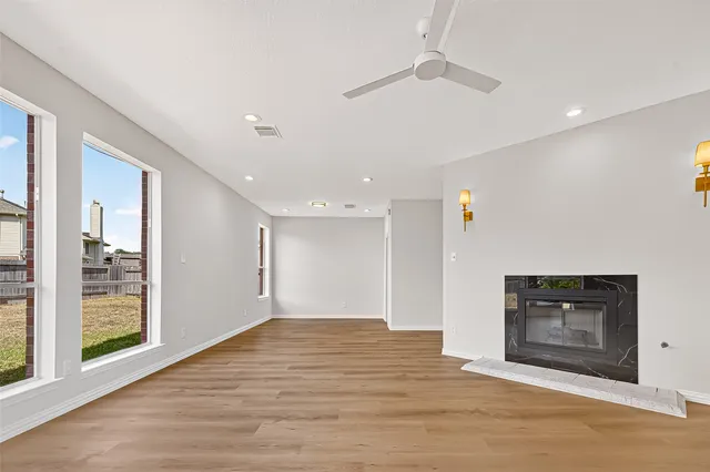 a view of empty room with wooden floor and fireplace