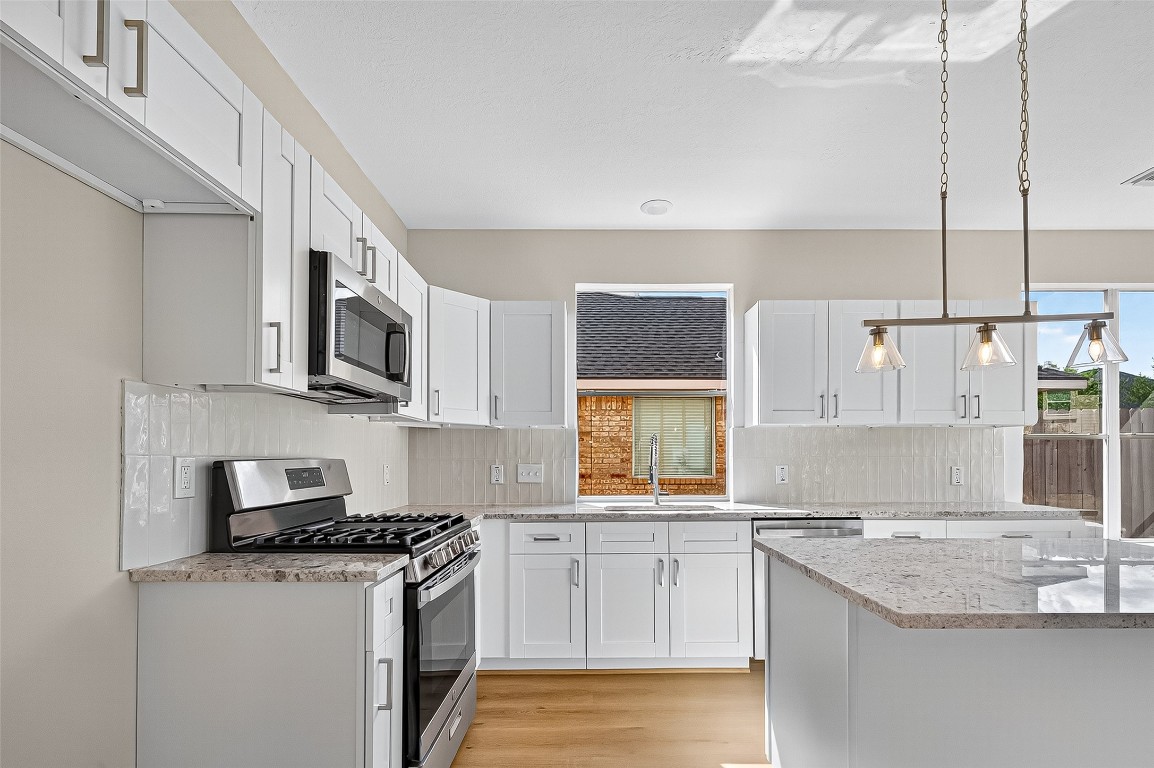 21310 Timber Pines Drive Spring, TX 77388 - Photo 20 of 49 a kitchen with stainless steel appliances granite countertop a sink stove and microwave
