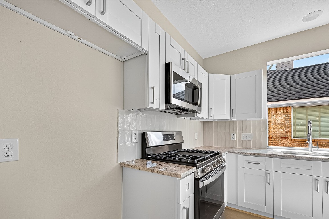 21310 Timber Pines Drive Spring, TX 77388 - Photo 22 of 49 a kitchen with stainless steel appliances white cabinets and a stove top oven