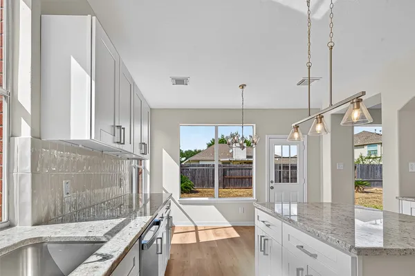 a open kitchen with granite countertop a sink and a refrigerator