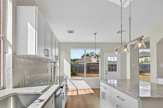 a open kitchen with granite countertop a sink and a refrigerator