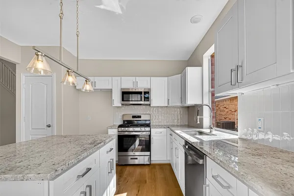 a kitchen with stainless steel appliances granite countertop a sink stove and refrigerator