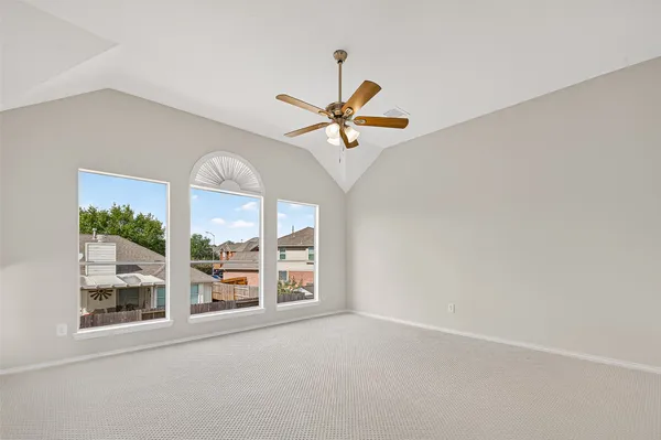 an empty room with windows and ceiling fan