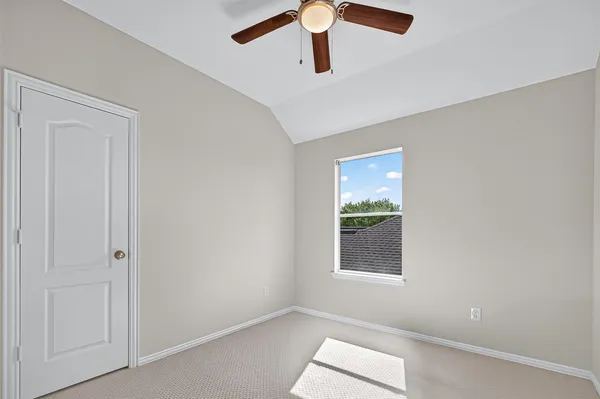 an empty room with a ceiling fan and wooden floor