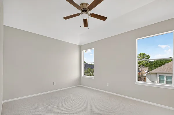 an empty room with a window and a fan