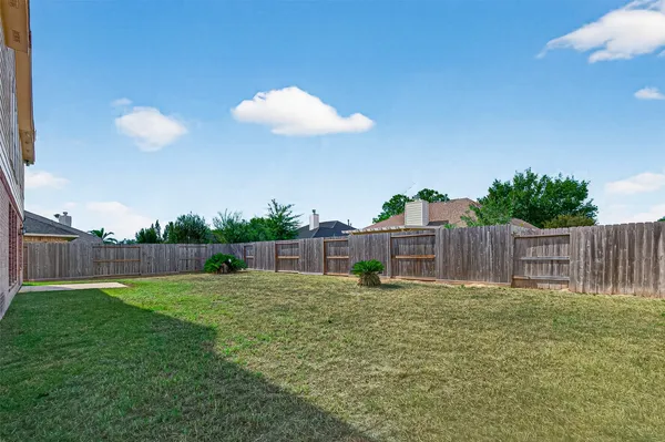 a view of a garden with a house in the background