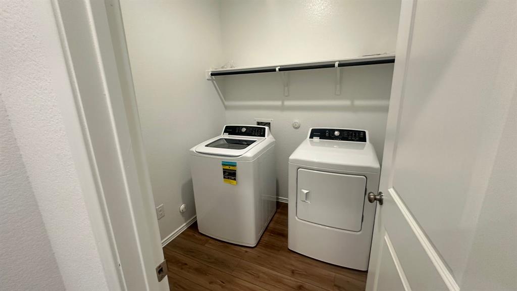 192 Rodney Boat Road Kyle, TX 78640 - Photo 5 of 38 A dedicated laundry closet offers convenient home organization with modern appliances and a practical overhead shelf.