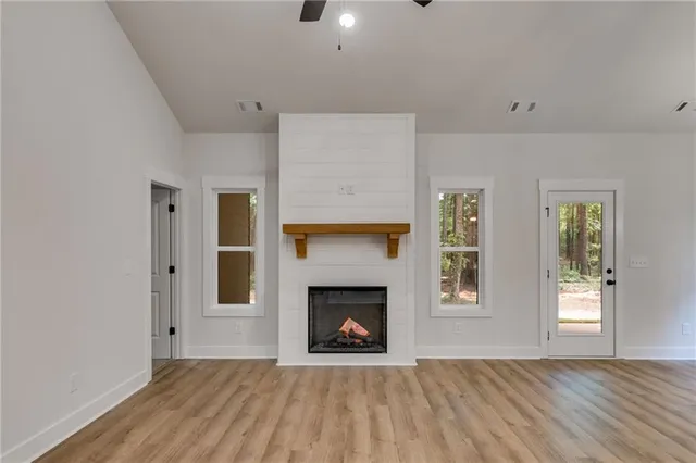 a view of an empty room with window and fire place