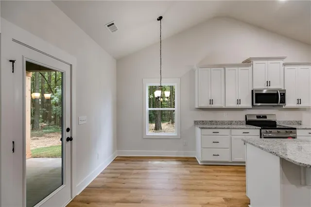 a kitchen with stainless steel appliances granite countertop a stove a sink and a microwave