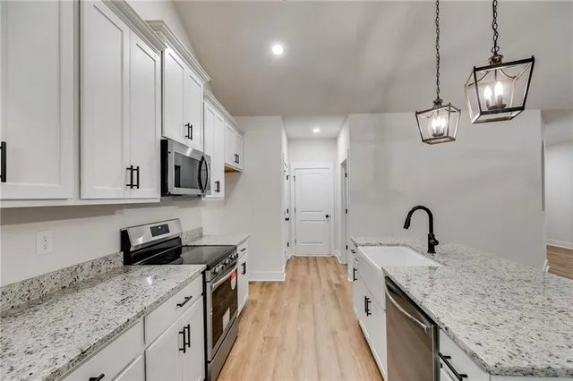 a kitchen with granite countertop a sink stainless steel appliances and cabinets