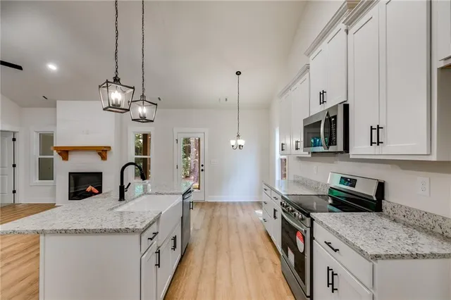 a kitchen with stainless steel appliances granite countertop a sink stove and refrigerator