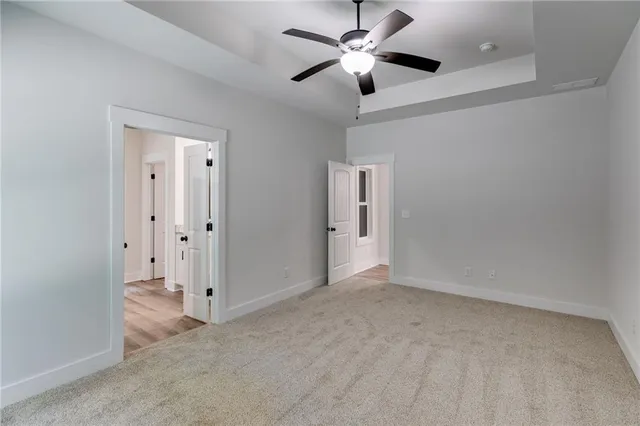 an empty room with chandelier fan and closet