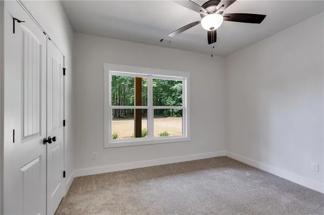 an empty room with a window and a fan