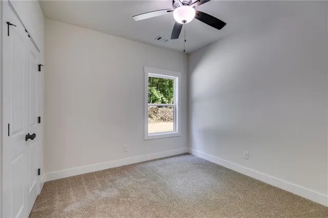 an empty room with a window and a fan