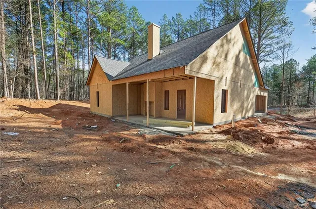 a view of a house with backyard and trees