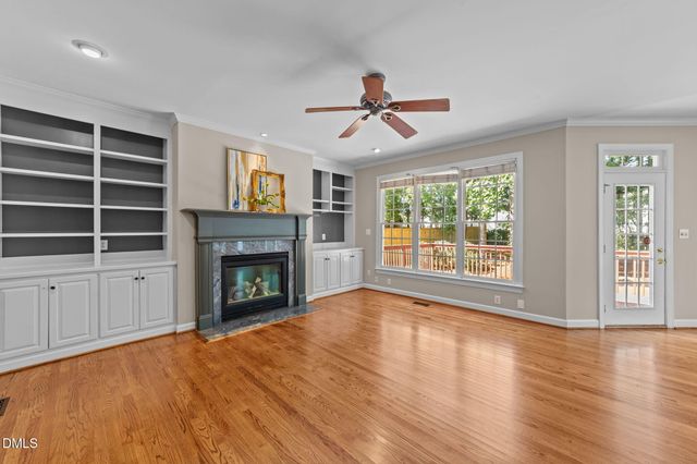 a view of empty room with wooden floor and fireplace
