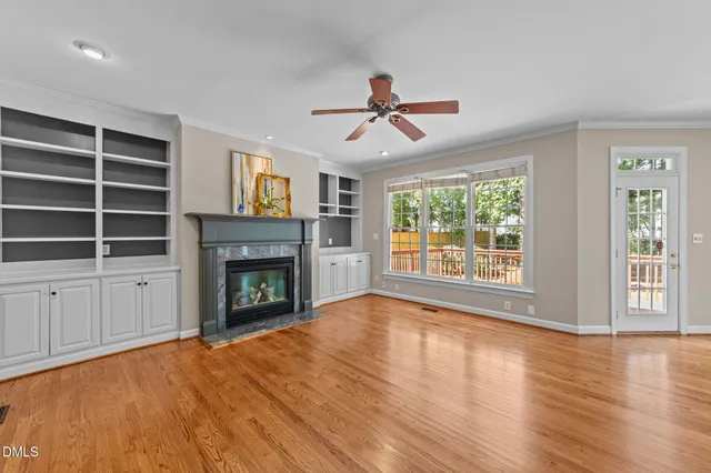 a view of empty room with wooden floor and fireplace