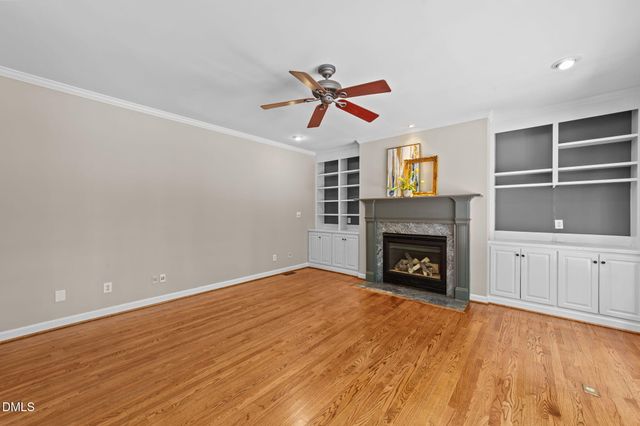 a view of an empty room with a fireplace and window