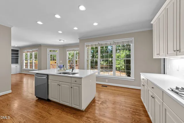 a large kitchen with stainless steel appliances granite countertop a sink and cabinets with wooden floor