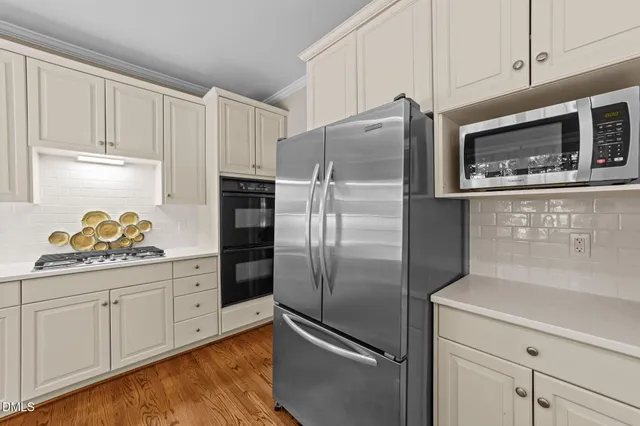 a kitchen with stainless steel appliances granite countertop a refrigerator and a stove top oven