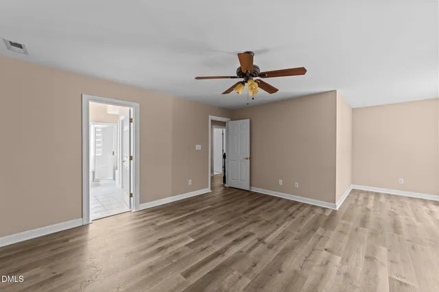 a view of room with wooden floor and ceiling fan