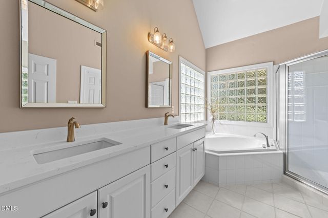 a bathroom with a tub sink and mirror