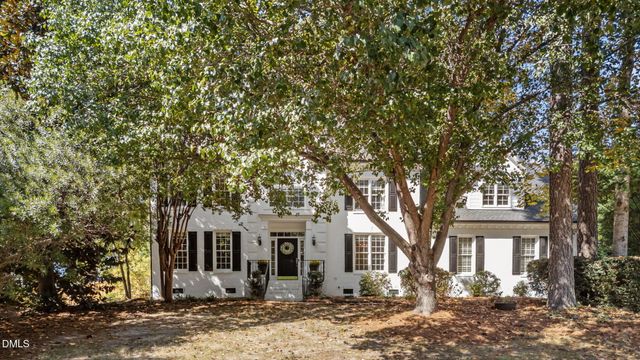 a front view of a house with a tree