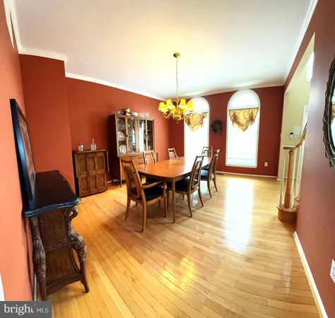 a dining room with furniture a chandelier and wooden floor